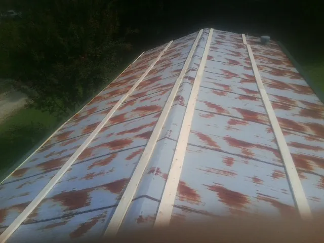 Rusted metal roof panels with new wood purlins before replacement — Storm Damage Roof Repair in Farley by Roofing Brothers