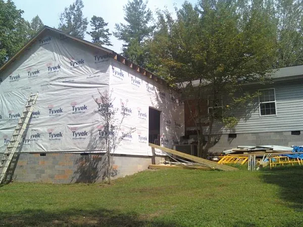 Tyvek wrapped gable on a new room addition beside an existing home in Farley